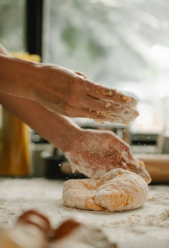 Mastering the First Impression: Your intriguing post title goes here Unrecognizable woman kneading fresh and soft egg dough on table with flour in bakery